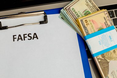 Fafsa. Öğrenci yardımı beyannamesi ve tablet üzerindeki para.