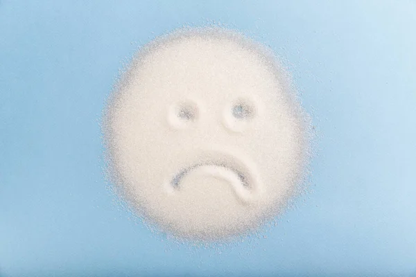 Сумний цукор обличчя на синьому фоні. Погана концепція їжі . — стокове фото