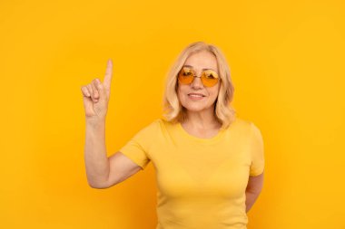 Sarı stüdyoda yalnız ve gülümseyen güzel bir bayan..