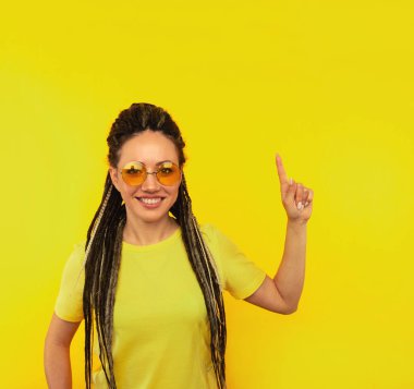 Sarı arka planda duran turuncu gözlüklü yakışıklı kadın..