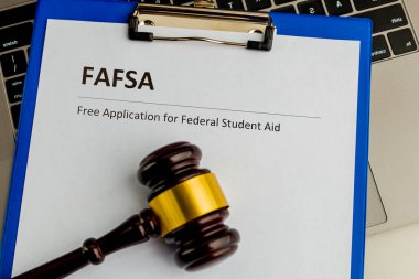 Öğrenci yardımı ve dizüstü bilgisayarlı ahşap tokmağın olduğu belge. Fafsa.