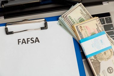 Fafsa. Öğrenci yardımı beyannamesi ve tablet üzerindeki para.