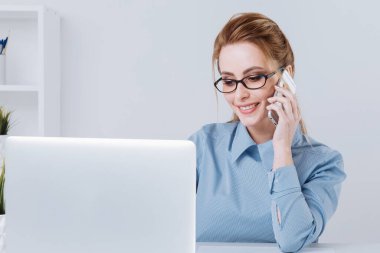 Güzel sarışın Ofis telefonu onun işyerinde konuşurken kız.