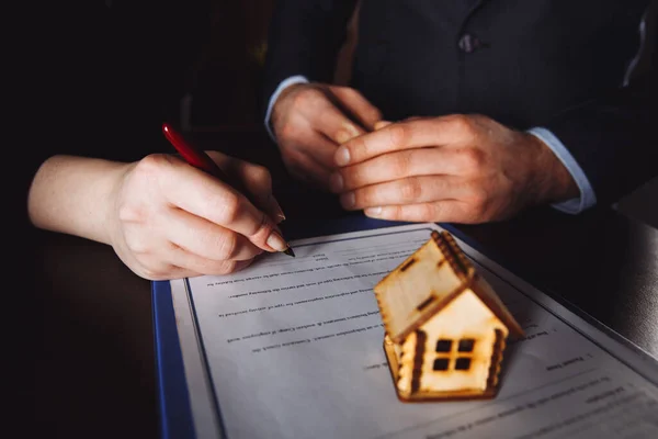 Llave de la casa en la mano del empleador bancario para vender la casa después de aprobar el préstamo y la firma del comprador en papel de contrato en la oficina . — Foto de Stock