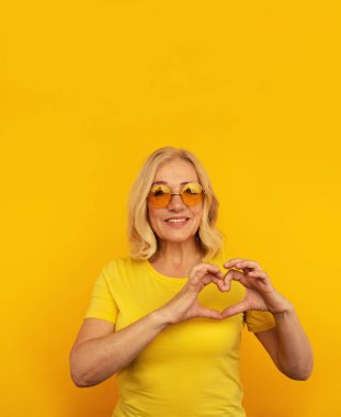 Gülümseyen olumlu kadın kalbini gösteriyor. Kendini izole et..