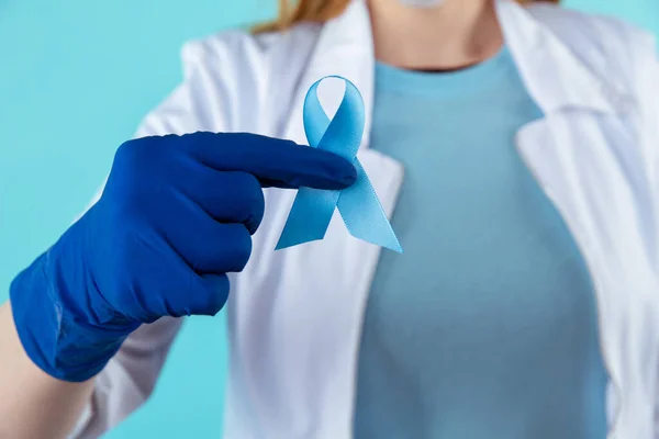 Doctor sosteniendo cinta azul, vista de cerca. Símbolo de problemas médicos. — Foto de Stock
