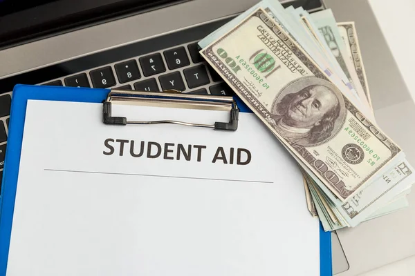 Fafsa. Student aid concept. Application form of document on the table with money.