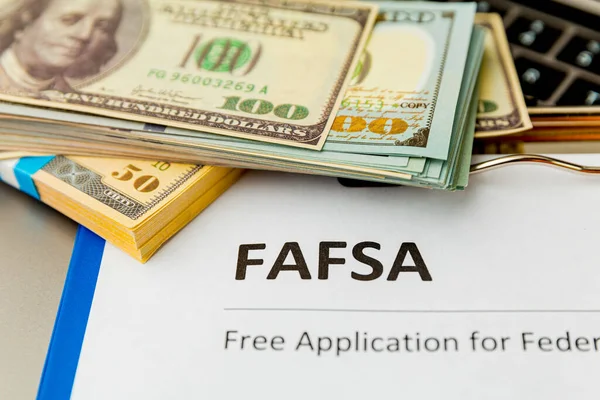 Fafsa. Student aid statement form and money on the tablet.