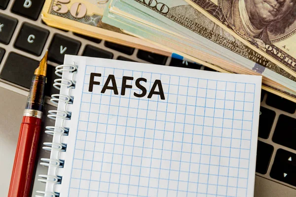 Fafsa. Student aid statement form and money on the tablet.