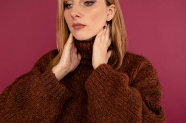 Boğaz ağrısı konsepti. Yakından bakınca, kazaklı bir kadın boynunu acıdan tutuyor..