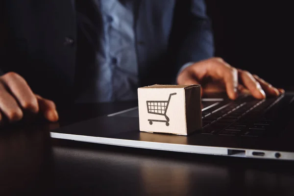 Cajas en un carro en un teclado portátil. Ideas sobre compras en línea, compras en línea es una forma de comercio electrónico que permite a los consumidores comprar directamente bienes de un vendedor a través de Internet. — Foto de Stock