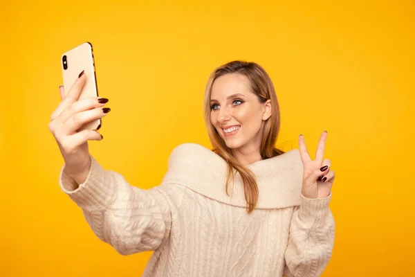 Potrait ženy, jak se sama fotí a ukazuje mírové znamení izolované. — Stock fotografie