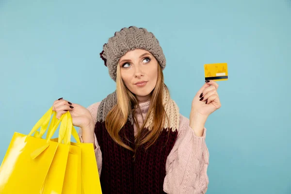 Zimní nakupování online koncept. Blond žena s kreditní kartou izolované. — Stock fotografie