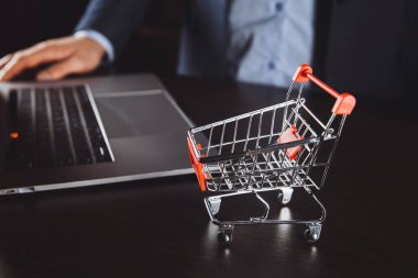 Dizüstü bilgisayarın klavyesindeki tramvayda kutular. Çevrimiçi alışveriş, çevrimiçi alışveriş, tüketicilerin internet üzerinden doğrudan mal satın almalarına olanak sağlayan bir tür elektronik ticarettir..