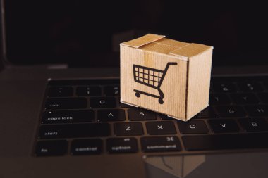 Dizüstü bilgisayarın klavyesindeki tramvayda kutular. Çevrimiçi alışveriş, çevrimiçi alışveriş, tüketicilerin internet üzerinden doğrudan mal satın almalarına olanak sağlayan bir tür elektronik ticarettir..