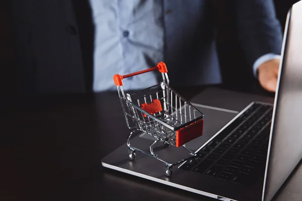 Boxen in einem Trolley auf einer Laptop-Tastatur. Ideen zum Online-Shopping: Online-Shopping ist eine Form des elektronischen Handels, die es Verbrauchern ermöglicht, Waren direkt von einem Verkäufer über das Internet zu kaufen. — Stockfoto