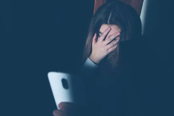 Adolescente excessivamente sentado ao telefone em casa. ele é vítima de bullying online redes sociais Stalker - Imagem — Fotografia de Stock