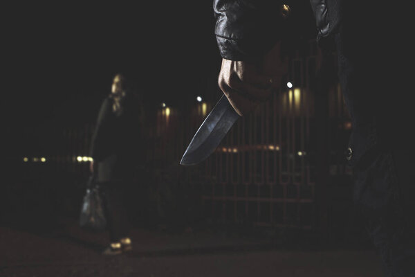 Концепции ограбления грабитель направил свой острый нож на женщину, чтобы ограбить ее ценные вещи в сумке
