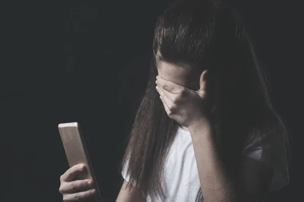 Молодая грустная уязвимая девушка, использующая мобильный телефон испуганный и отчаянный страдает интернет-злоупотребления киберзапугивания преследуют — стоковое фото