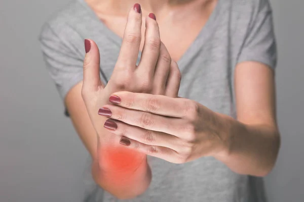 Mujer mayor que sufre de dolor, debilidad y hormigueo en la muñeca. Las causas de dolor incluyen osteoartritis, artritis reumatoide, gota o esguince de muñeca. Asistencia sanitaria —  Fotos de Stock