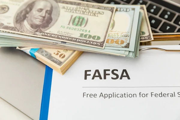 Fafsa. Student aid statement form and money on the tablet.