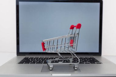 Dizüstü bilgisayar ve küçük araba beyaz arka plan üzerinde. Internet alışveriş kavramı
