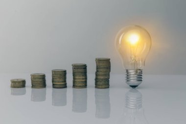 Bozuk para dolu bir ampulü tutan el. Para biriktirmek için yaratıcı fikirler. Gelecek için para yönetimi