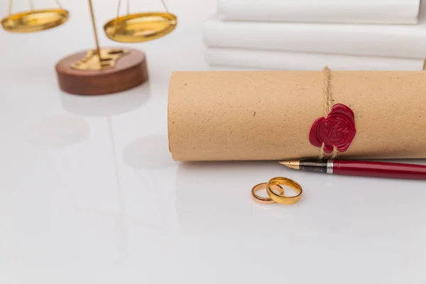 Scheidingsconcept. Gouden ringen op tafel met houten hamer en geld. — Stockfoto