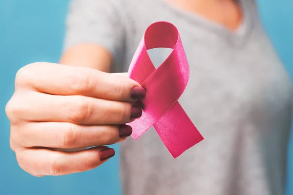 Womaen mano sosteniendo cinta rosa conciencia de cáncer de mama. concepto de asistencia sanitaria y — Foto de Stock