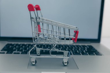 Dizüstü bilgisayar ve küçük araba beyaz arka plan üzerinde. Internet alışveriş kavramı