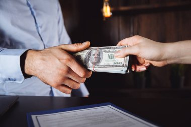 Adam yüz dolarlık banknotlar teklif ediyor. Eller yukarı. Satış, rüşvet, yolsuzluk konsepti. El çabukluğu, Amerikan Doları veya Amerikan Doları. İş adamından el ile para almak.