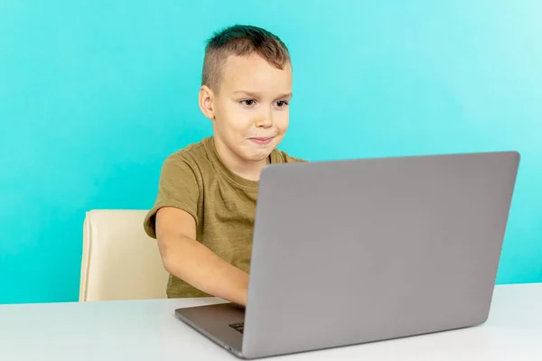 Criança estudando on-line em casa no laptop na sala azul . — Fotografia de Stock