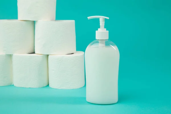 Un sacco di carta igienica e una bottiglia di sapone sullo sfondo blu. Tempo di pandemia . — Foto Stock