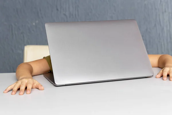 Thuis afstandsonderwijs. Moe kind zit aan het bureau voor de laptop. — Stockfoto