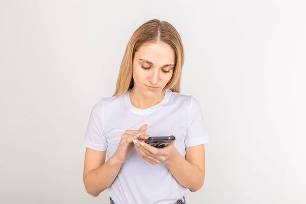 Ritratto di una donna casuale che tiene lo smartphone su sfondo bianco — Foto Stock