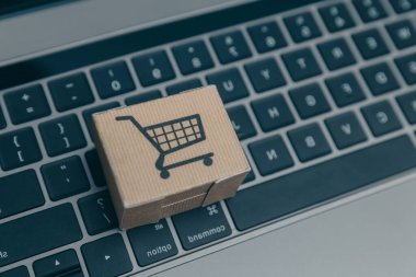 Dizüstü bilgisayar ve küçük araba beyaz arka plan üzerinde. Internet alışveriş kavramı
