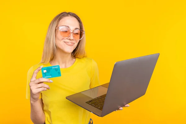 Kobieta w żółtym t-shirt zakupy online z karty kredytowej i komputera. Koncepcja zakupów internetowych — Zdjęcie stockowe