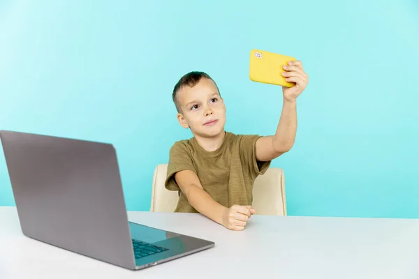Criança estudando on-line em casa no laptop na sala azul . — Fotografia de Stock