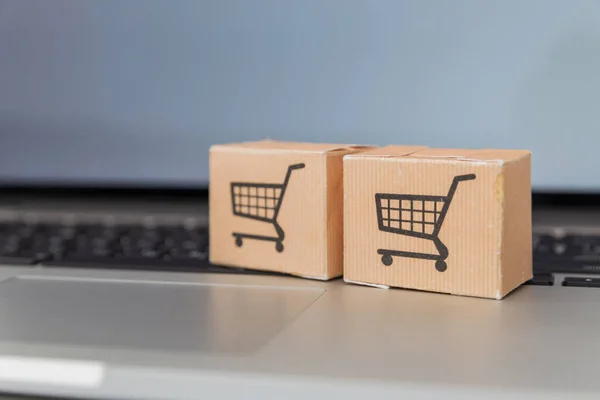 Portátil y carrito pequeño sobre fondo blanco. Concepto de compras por Internet — Foto de Stock