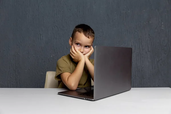 Overstuur jongen zitten en studeren op de computer online in quarantaine tijd. — Stockfoto
