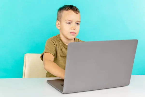 Kind studeren online thuis op de laptop in de blauwe kamer. — Stockfoto