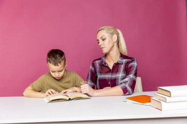 Annesiyle ödev yapan küçük bir okul çocuğu, aile içi işbirliği, ebeveynlik.