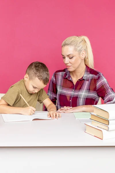 ピンクの部屋で一緒に宿題をする子供との講師. — ストック写真