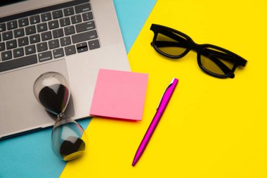 Klavyesi, kum saati ve pembe yapışkan notası olan yaratıcı bir ev işi yeri. Ev kavramından çalış