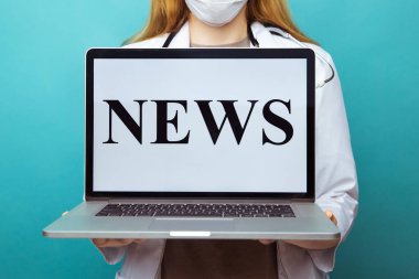 Genç bayan doktor dizüstü bilgisayarında Coronavirus ve karantina hakkında mavi arka planda izole haberler tutuyor.