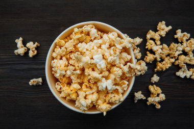 Tahta zemin üzerinde patlamış mısır olan bir kase. Üst Manzara. Tuzaklama konsepti