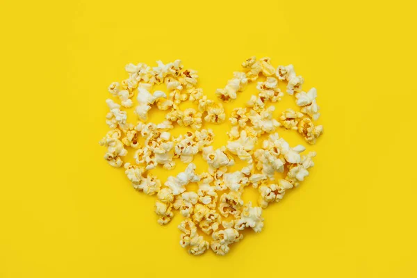 Love Cinema koncept popcorn uspořádány ve tvaru srdce na žlutém pozadí — Stock fotografie