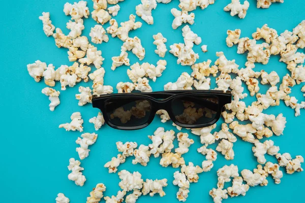 Popcorn a 3D brýle pro film jsou na modrém zadečku. Horní pohled — Stock fotografie