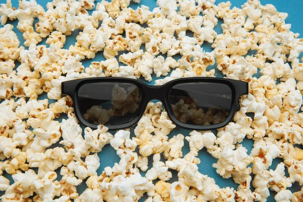 Popcorn e occhiali 3d per il film sono sul backgound blu. Vista dall'alto — Foto Stock