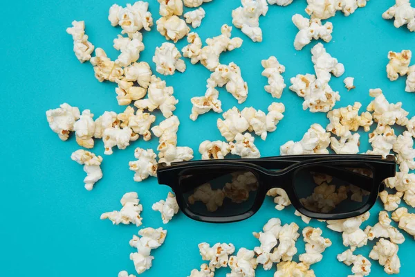 Popcorn e occhiali 3d per il film sono sul backgound blu. Vista dall'alto — Foto Stock